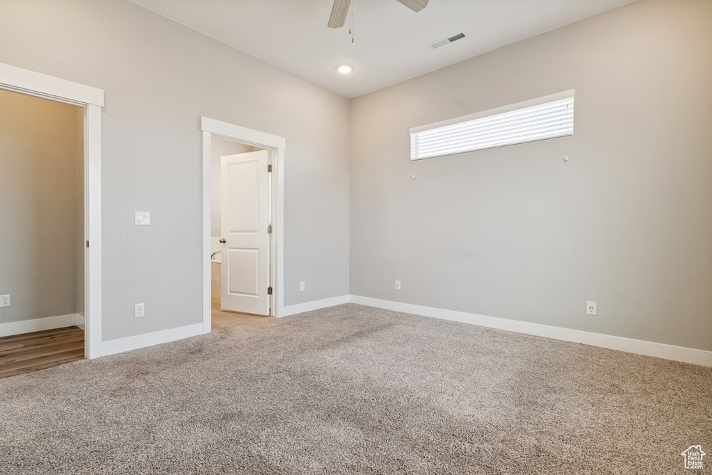 Unfurnished room with light colored carpet and ceiling fan