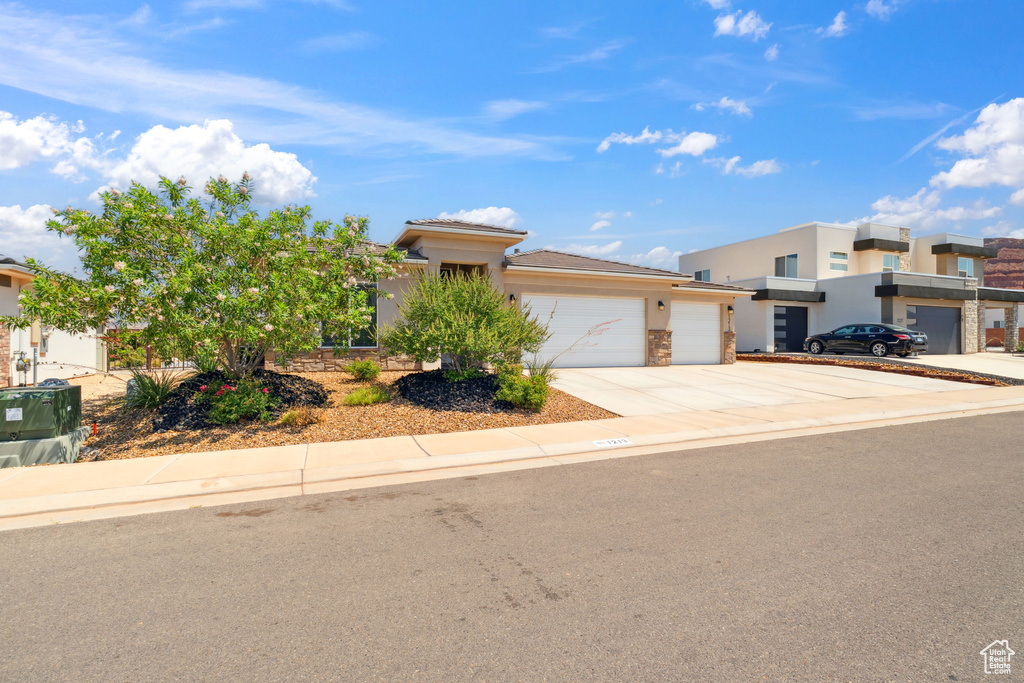 View of front of home with concrete driveway, a garage, and stucco siding