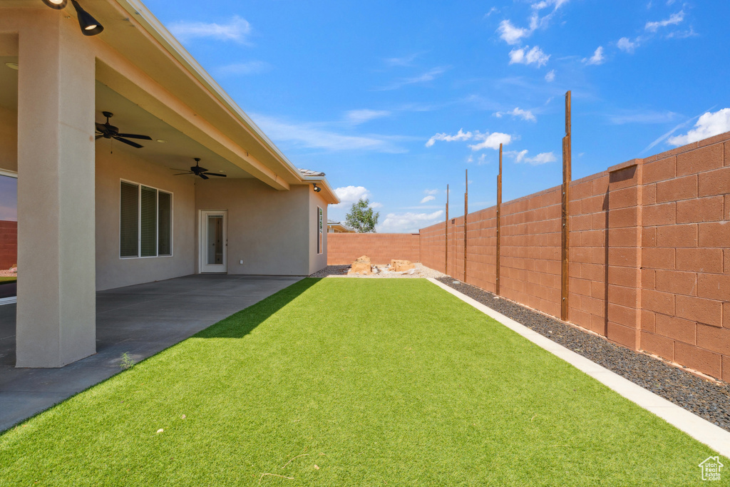 Fenced backyard with ceiling fan and a patio