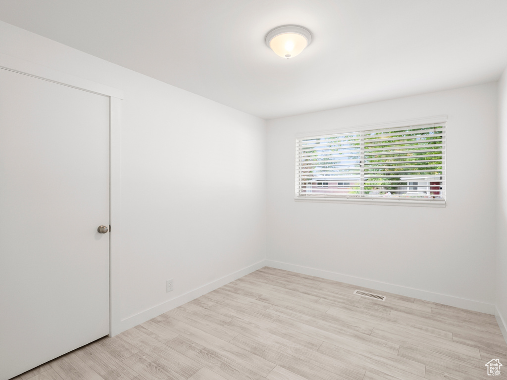 Empty room featuring light wood-type flooring and baseboards