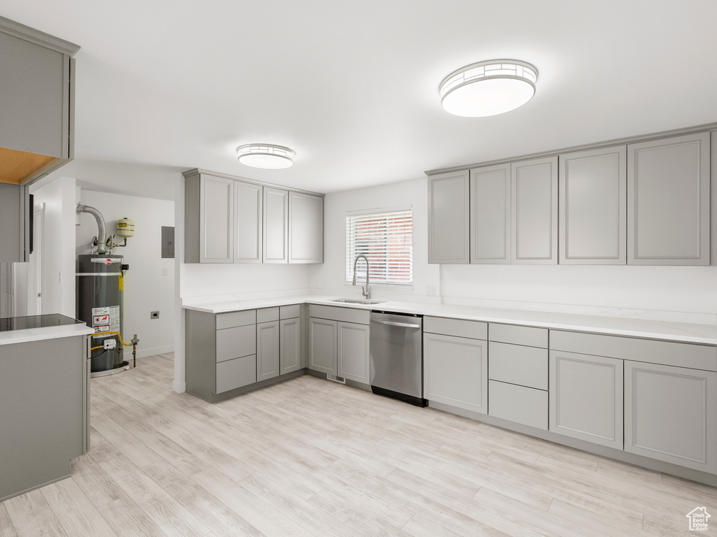 Kitchen with gray cabinets, dishwasher, water heater, light wood-style flooring, and light countertops