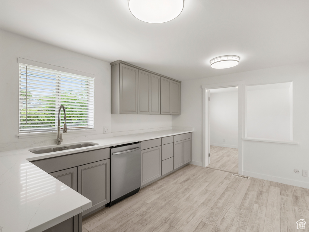 Kitchen featuring dishwasher, gray cabinets, and light wood finished floors