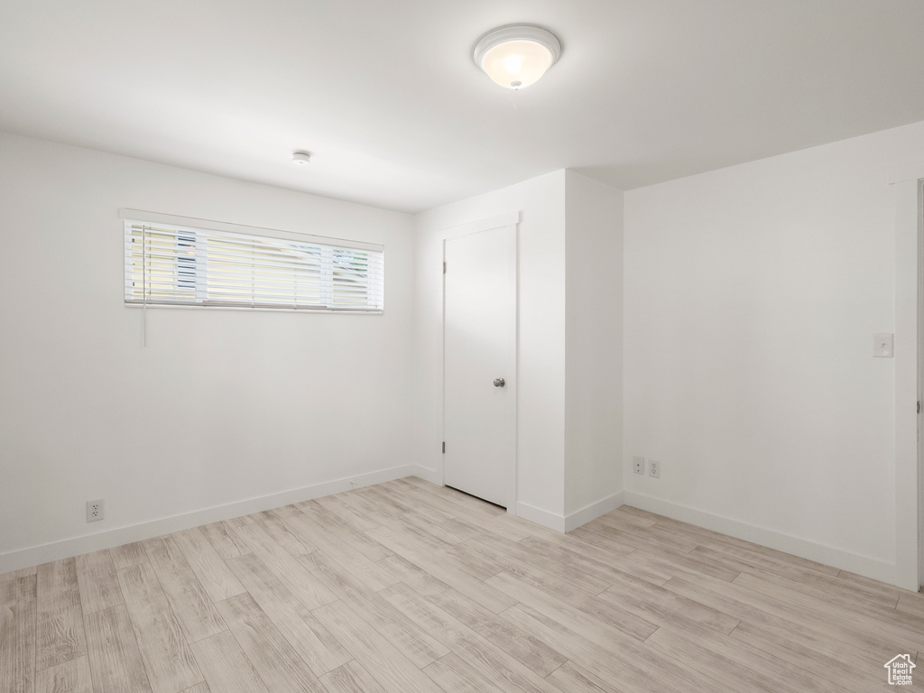 Unfurnished room with light wood-type flooring and baseboards