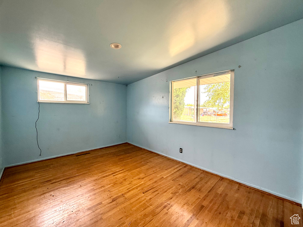 Unfurnished room featuring healthy amount of natural light and hardwood / wood-style flooring