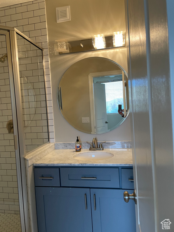 Bathroom featuring a shower stall and vanity