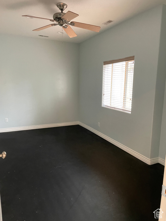 Empty room with baseboards and a ceiling fan