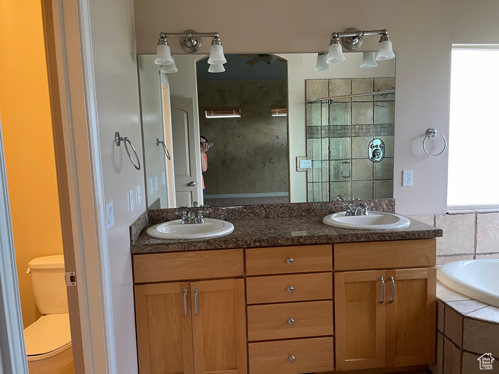 Full bath with double vanity, a bath, and a tile shower