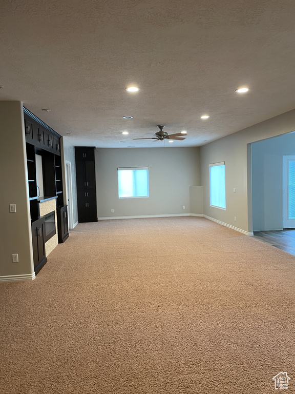 Unfurnished living room with light carpet, a ceiling fan, and recessed lighting
