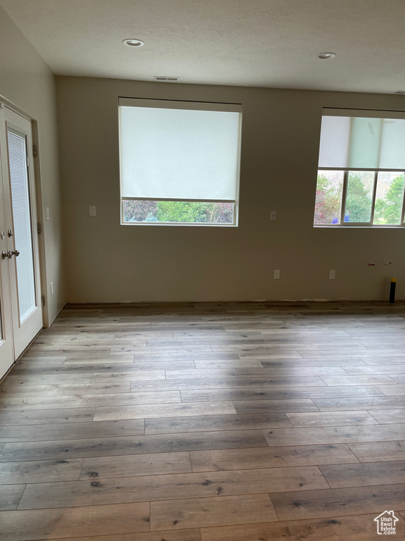 Spare room with light wood-style floors and recessed lighting