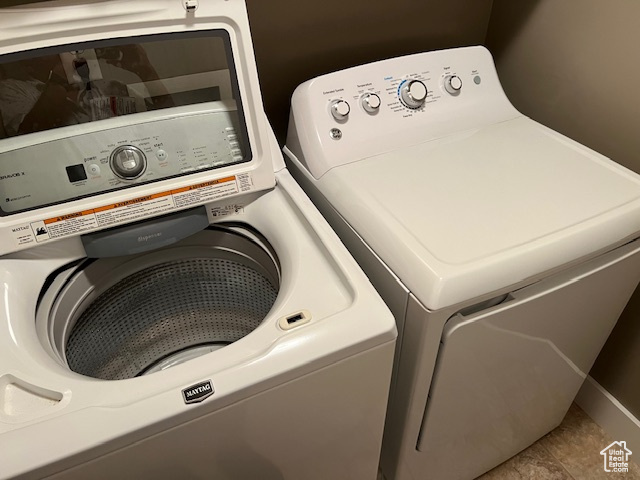 Laundry area with separate washer and dryer and tile patterned flooring
