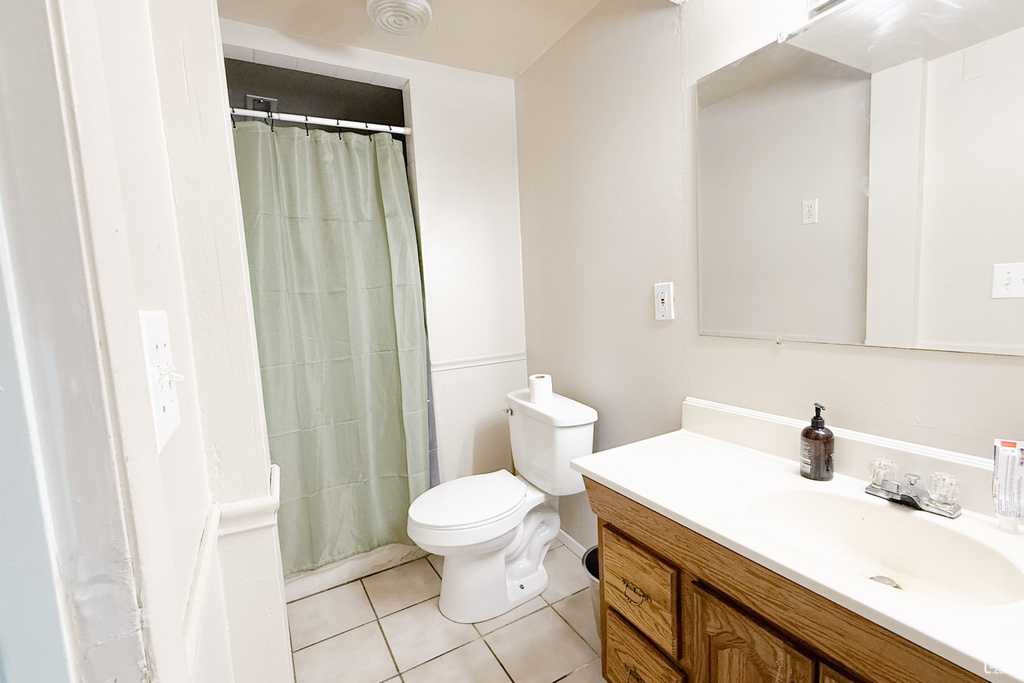 Bathroom featuring tile patterned floors, vanity, and curtained shower