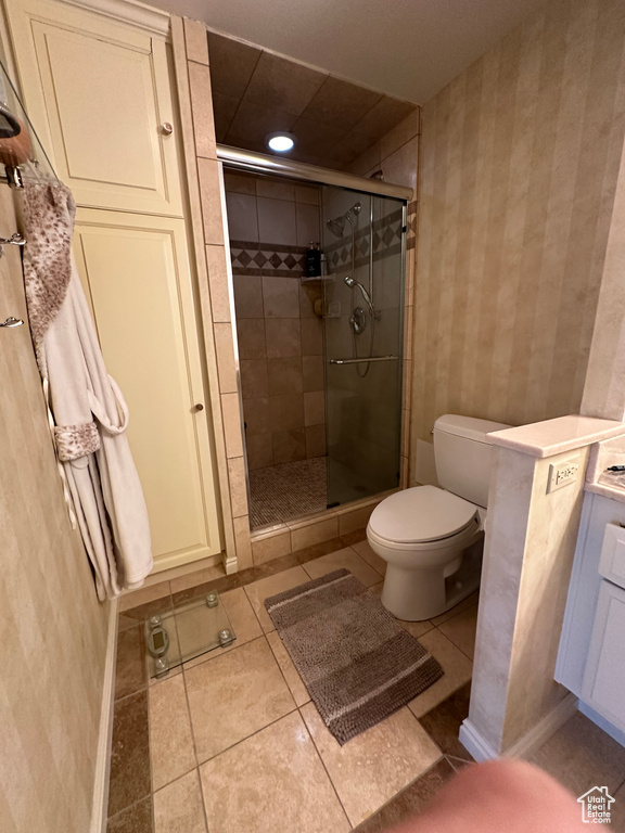 Bathroom with wallpapered walls, a shower stall, tile patterned flooring, vanity, and recessed lighting
