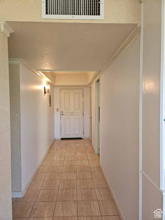 Corridor featuring ornamental molding and a textured ceiling