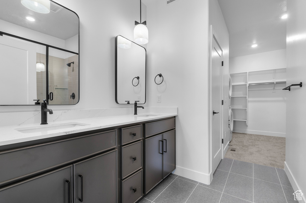Full bathroom with double vanity, a spacious closet, a shower stall, recessed lighting, and tile patterned flooring