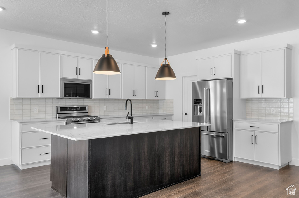 Kitchen featuring stainless steel appliances, tasteful backsplash, dark wood finished floors, recessed lighting, and hanging light fixtures