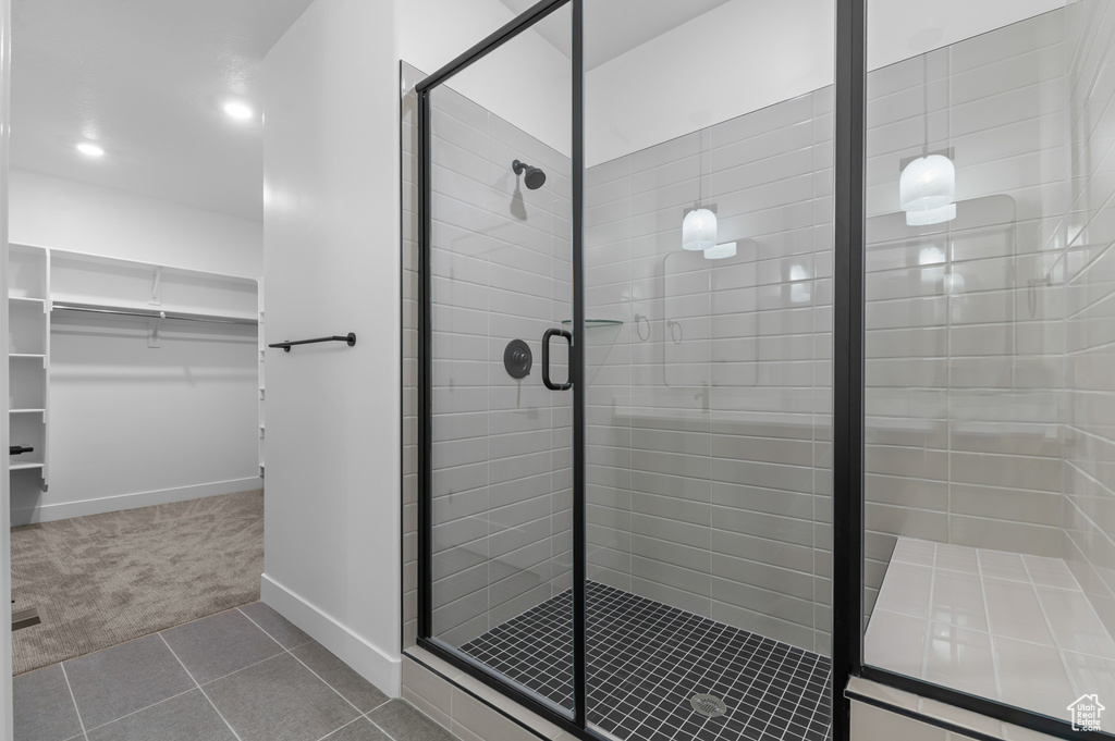 Bathroom featuring a stall shower, a spacious closet, tile patterned flooring, and recessed lighting