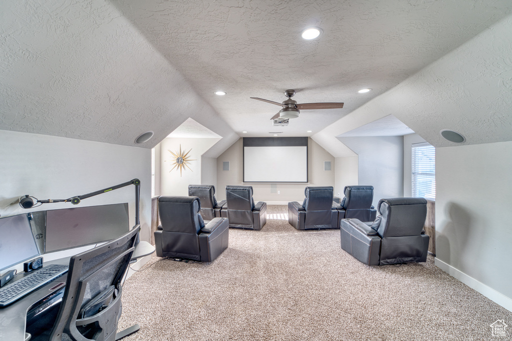 Home theater with a textured ceiling, carpet, lofted ceiling, ceiling fan, and recessed lighting