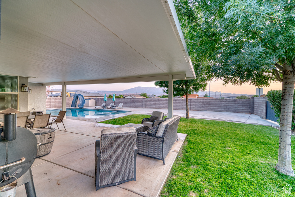 Patio terrace at dusk with a patio area, a fenced backyard, and outdoor dining area