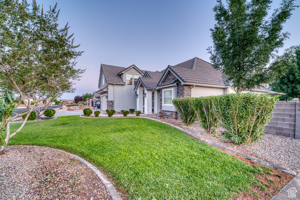 View of front of home with stone siding, stucco siding, and a tiled roof