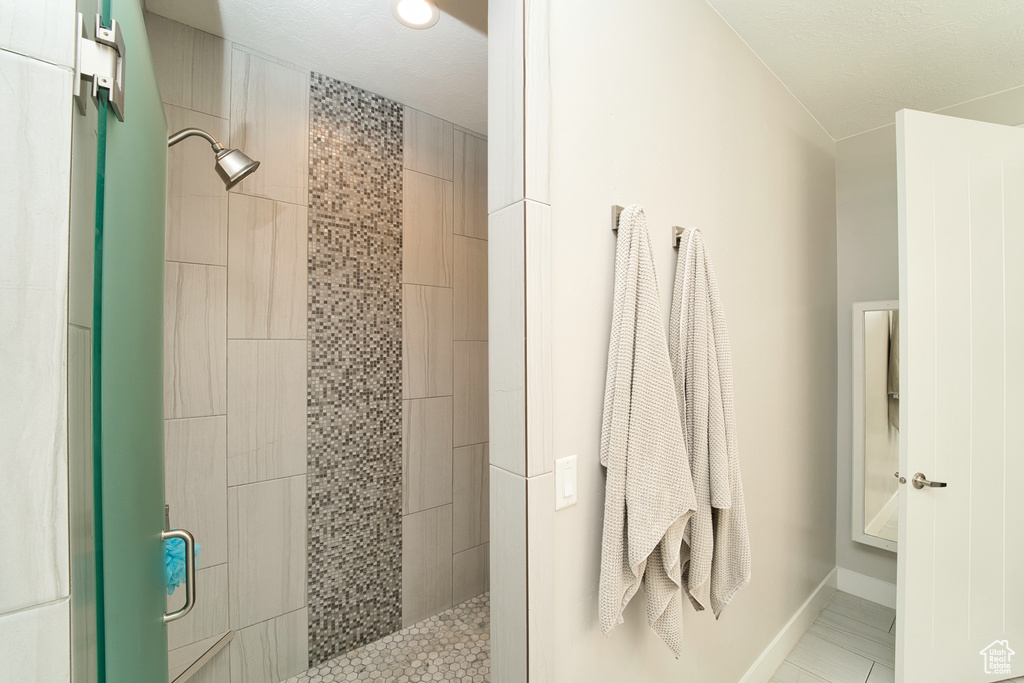 Full bathroom with a tile shower and tile patterned flooring