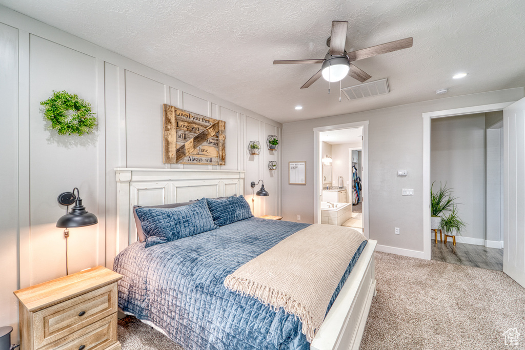 Carpeted bedroom featuring recessed lighting, connected bathroom, a ceiling fan, and a textured ceiling