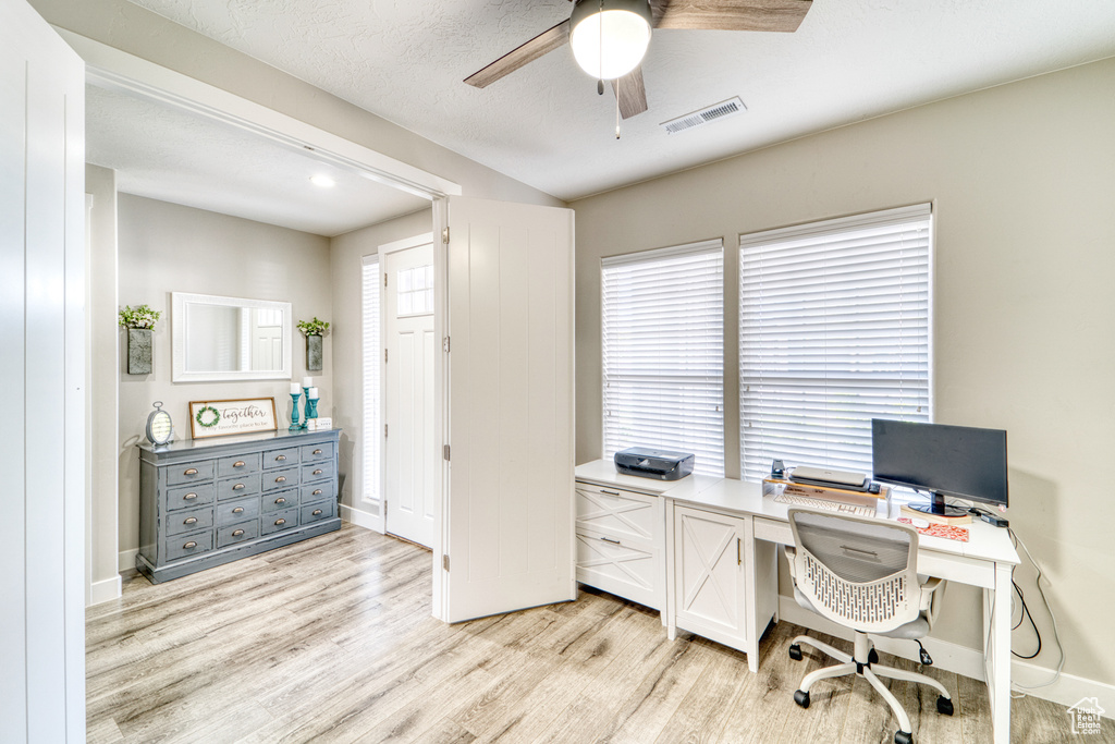 Office area with a ceiling fan and light wood-style floors