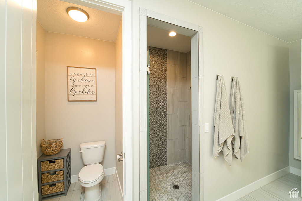 Bathroom with a tile shower and tile patterned flooring