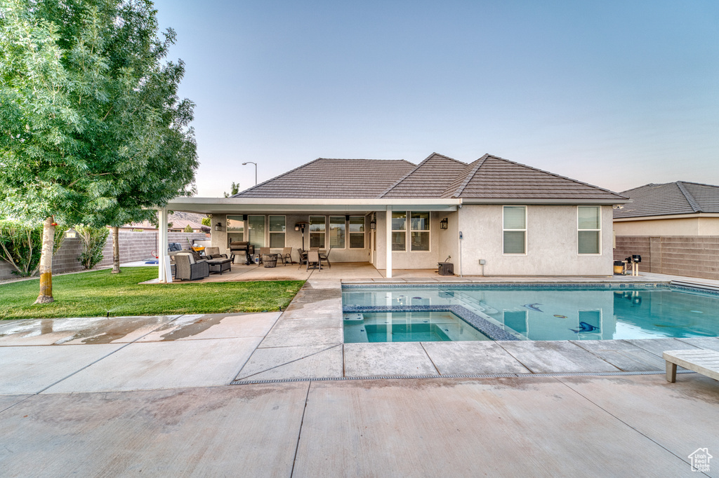 View of pool with outdoor lounge area, a patio area, a fenced backyard, and a pool with connected hot tub
