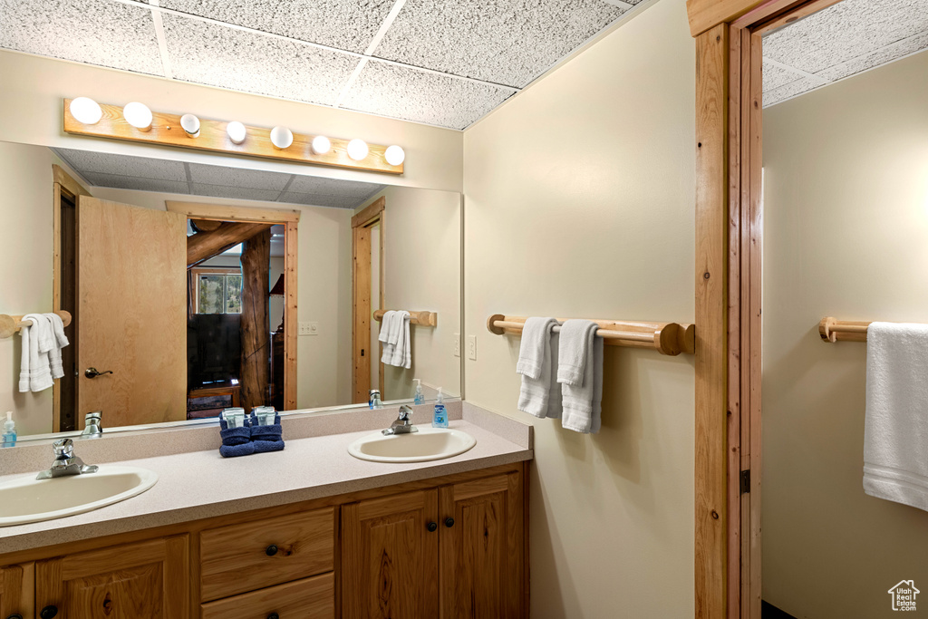 Full bathroom featuring a drop ceiling and double vanity