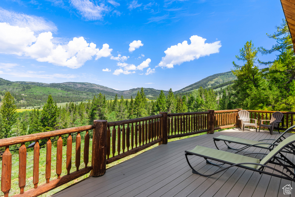 Deck featuring a mountain view and a view of trees