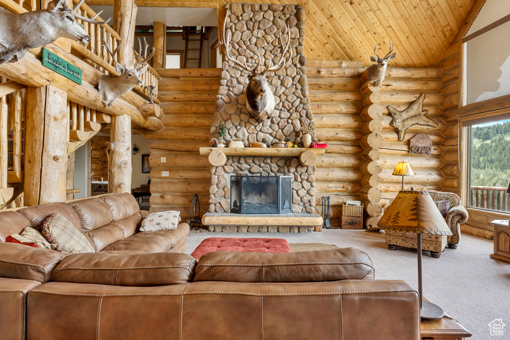 Living room with carpet flooring, log walls, high vaulted ceiling, wood ceiling, and a stone fireplace