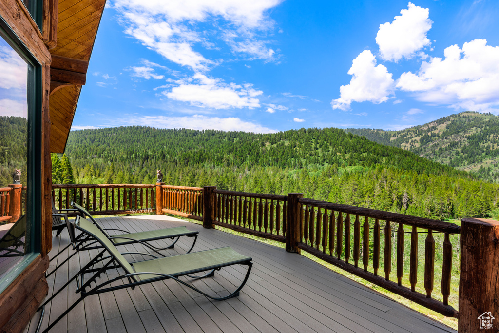 Wooden deck with a forest view and a mountain view