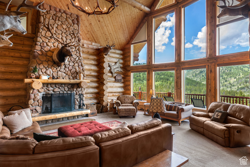 Carpeted living room featuring high vaulted ceiling, rustic walls, wood ceiling, a chandelier, and a stone fireplace