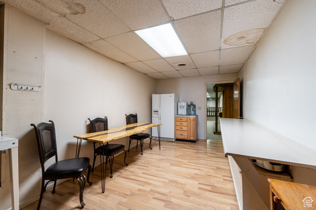 Office with a drop ceiling and light wood-style floors