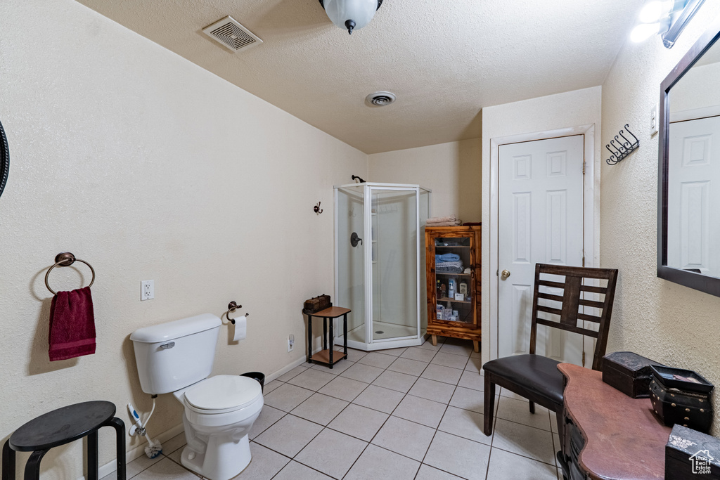 Bathroom featuring a shower stall and tile patterned flooring
