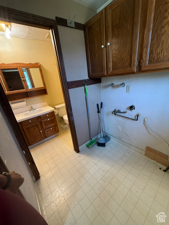 Laundry area with a sink and light floors