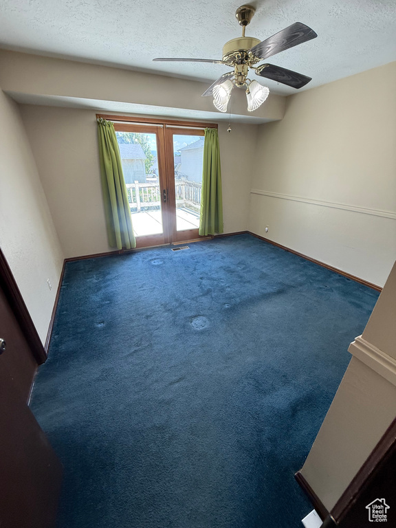 Spare room with french doors, a textured ceiling, carpet floors, and ceiling fan