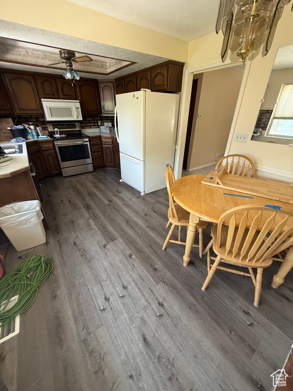 Kitchen with white appliances, dark wood-style floors, ceiling fan, and dark brown cabinetry