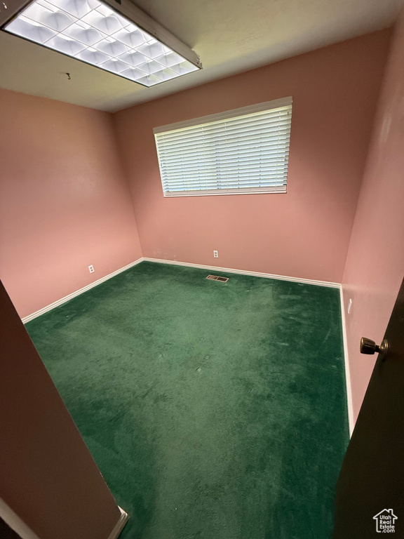 Empty room with dark carpet and baseboards