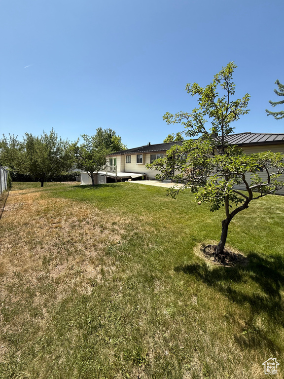 View of grassy yard with a wooden deck