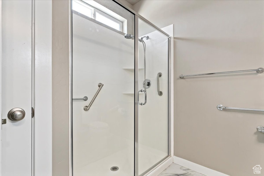 Bathroom featuring a stall shower and marble finish flooring