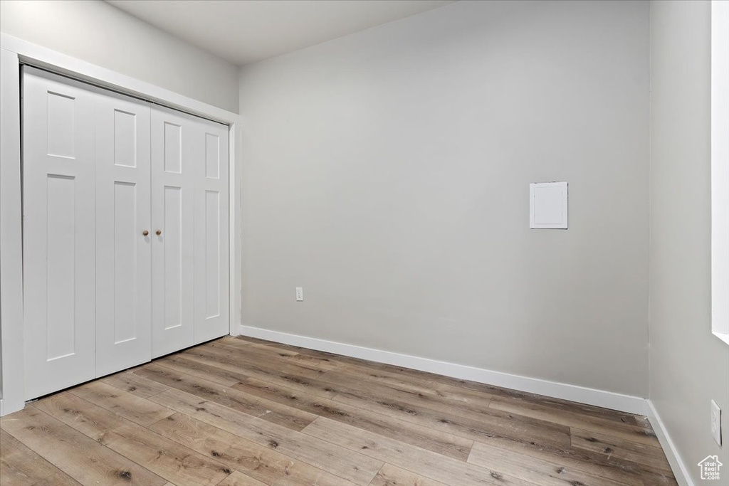 Unfurnished bedroom with light wood-style floors and a closet