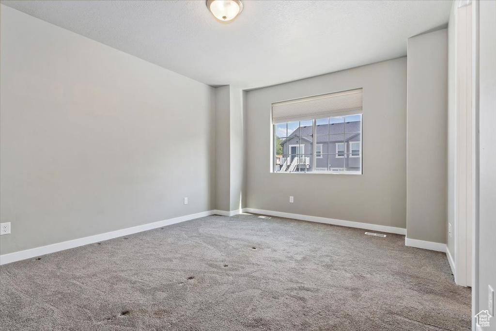 Carpeted empty room featuring baseboards