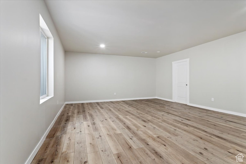 Empty room featuring light wood-style flooring, recessed lighting, and plenty of natural light