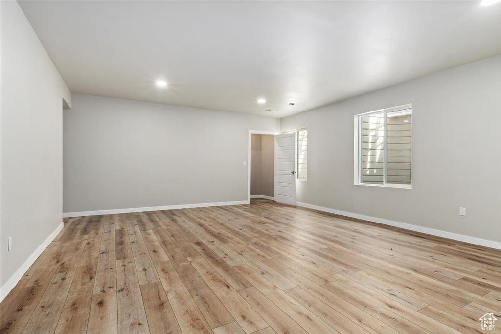 Empty room with hardwood / wood-style flooring and recessed lighting