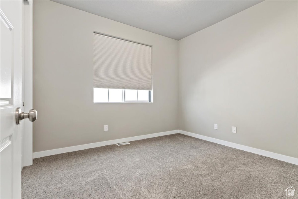 Carpeted spare room with baseboards