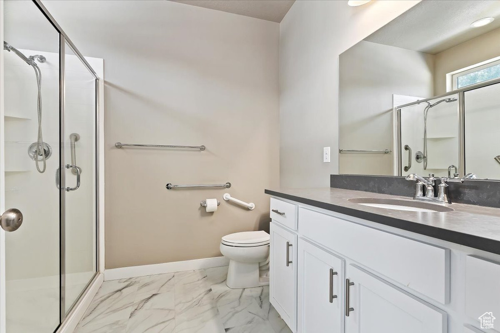 Full bathroom featuring a stall shower, vanity, and marble look tile flooring