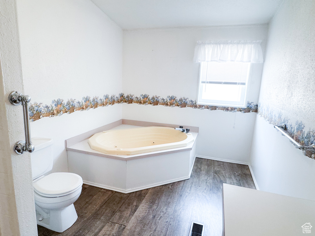 Bathroom featuring wood finished floors and a jetted tub