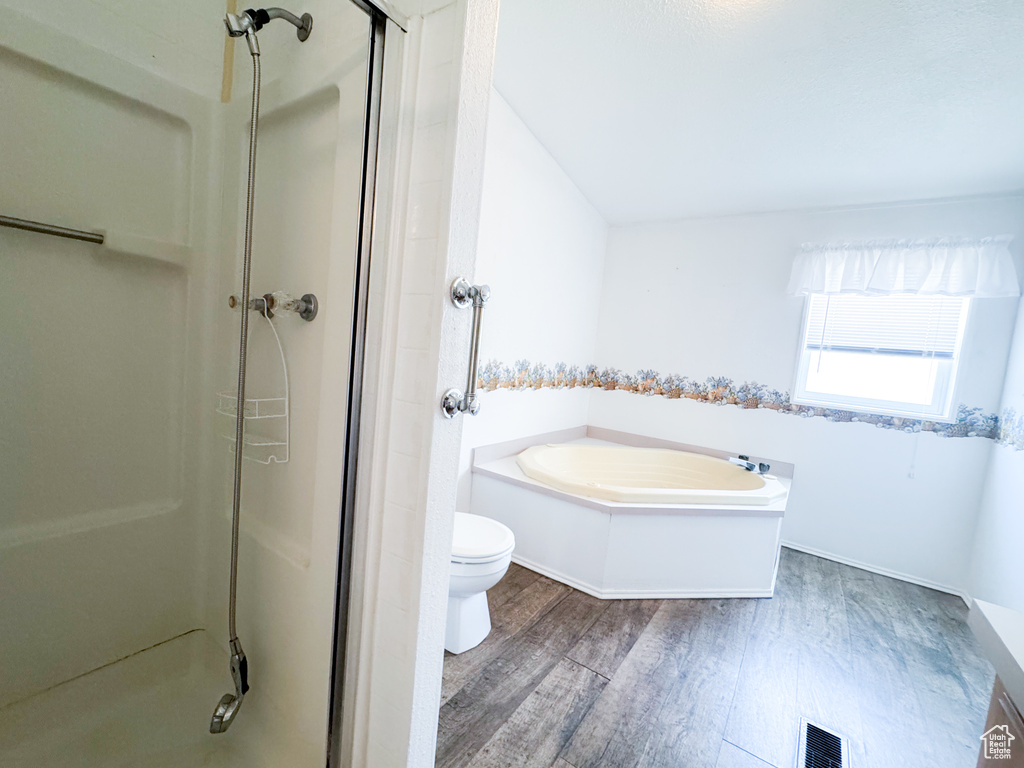 Full bath featuring wood finished floors, a shower stall, and a garden tub