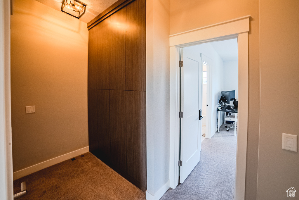 Corridor featuring carpet floors and baseboards